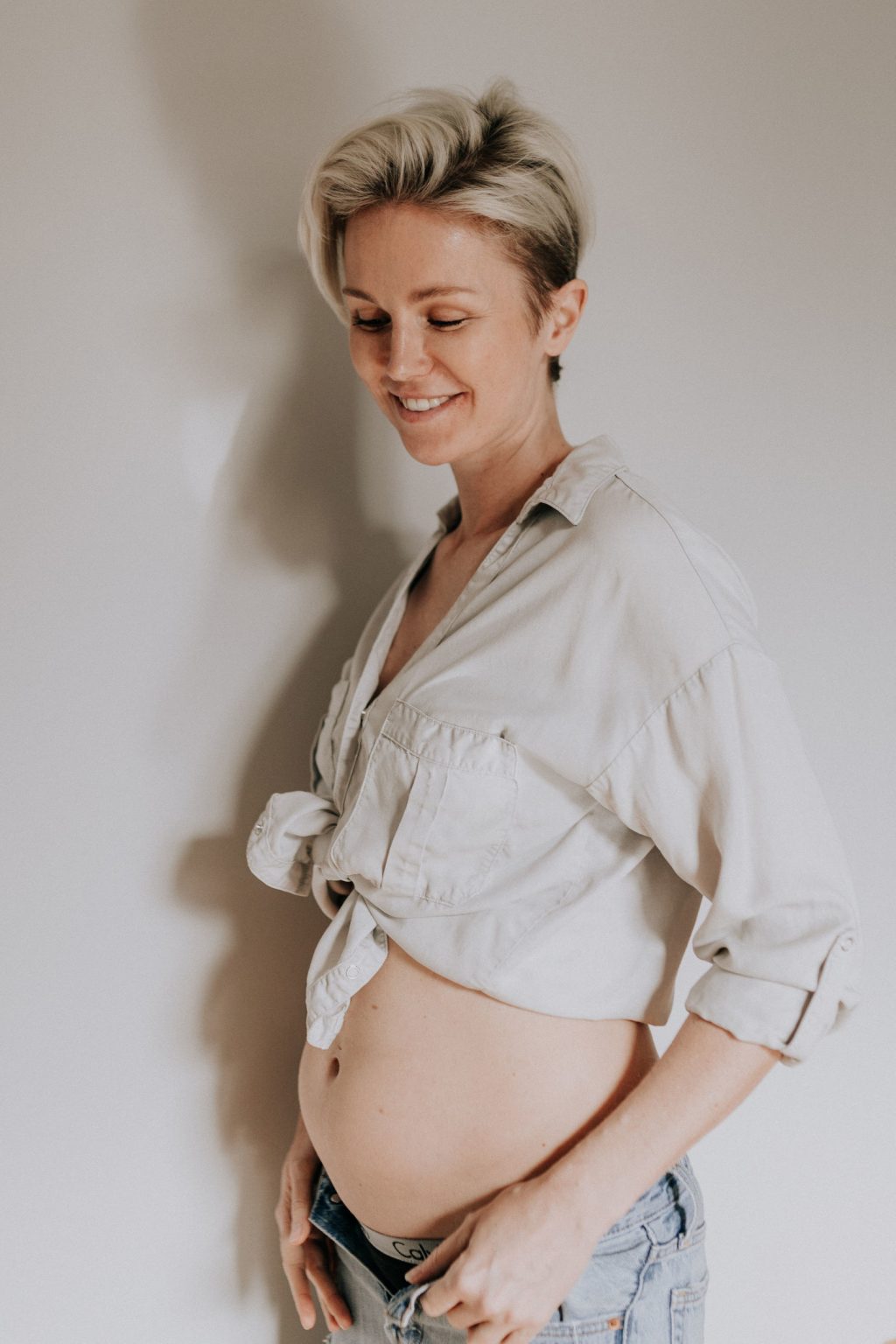 Schwangere Frau in hochgeschnürrter Bluse